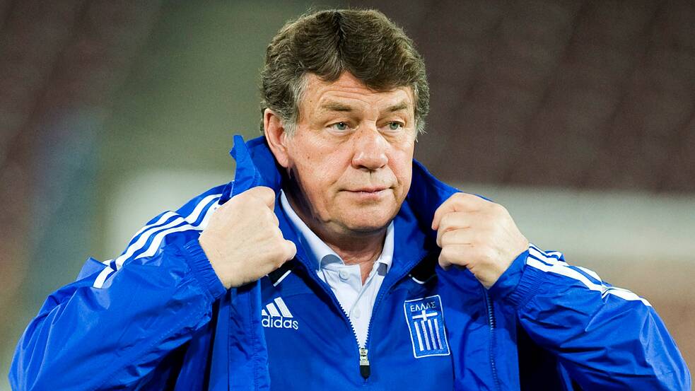 Former Greece national team coach Otto Rehagel adjusts his royal blue training jacket.