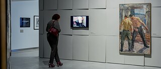 Photo is showing a woman is watching an art piece in the MO museum in Vilnius, Lithuania. 