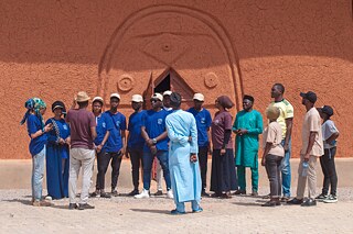 Connectig the Dots Fellows in front of a mud wall in Kaduna