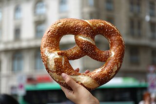 One hand holds a large brezel