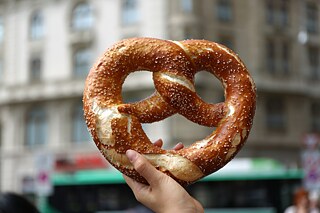 Eine Hand hält eine große Brezel