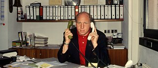 Dieter Hoeneß at his desk in the office with telephone receivers