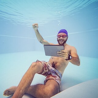 Mann mit Laptop unter Wasser