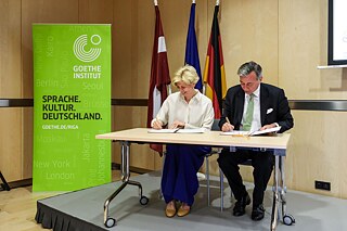 Deutscher Botschafter in Riga, Christian Heldt, und die lettische Bildungsministerin, Anda Čakša, unterzeichnen die gemeinsame Absichtserklärung zur zügigen Ausbildung von Deutschlehrkräften.