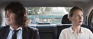 Ένας άνδρας και μια γυναίκα κάθονται σε ένα αυτοκίνητο και κοιτάζουν προς διαφορετικές κατευθύνσεις