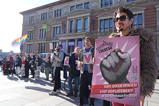 Allessandro (r) hält vor dem Berliner Abgeordnetenhaus ein Plakat mit der Aufschrift "Tuntenhaus bleibt - Save queer Spaces".