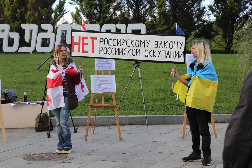 Evgenia und ihr Sohn Fjodor tragen ein Transparent mit der Aufschrift „Nein zum russischen Gesetz, Nein zur russischen Besatzung“.