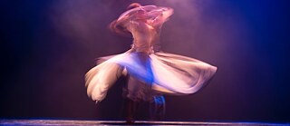 A person dances and spins so fast that he or she appears blurred