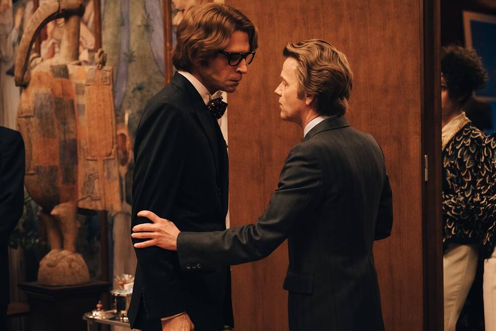 In a scene from the series 'Becoming Karl Lagerfeld', Pierre Bergé stands in front of Yves Saint-Laurent and grabs him by the arm