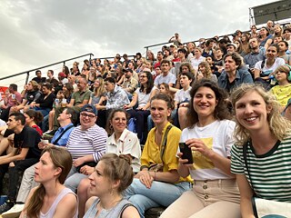 mehrere Menschen sitzen in einem Amphitheater