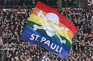 St. Pauli Fans mit Regenbogenfahne im Millerntorstadion nahe der Hamburger Reeperbahn im Februar 2024