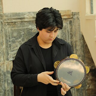 Merj Feras during workshop playing percussion 