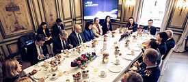 Eine Gruppe von Menschen sitzt um einen gedeckten Tisch bei der Münchner Sicherheitskonferenz 2024.