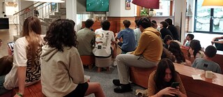 Jugendliche verfolgen gespannt ein Fußballspiel am Fernseher.