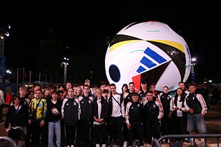 Підлітки в темряві стоять біля великого футбольного м"яча