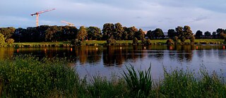 Blick auf den Werdersee in der Abendsonne. Im Hintergrund zwei Baukräne.