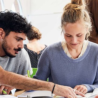 Zwei Lernende arbeiten konzentriert gemeinsam im Sprachkurs.