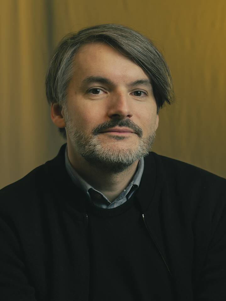 Autorenfoto von Saša Stanišić vor dunklem Hintergrund