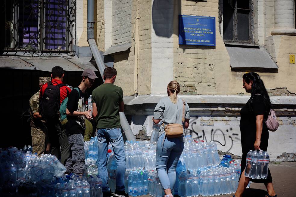 Engagierte Ukrainer*innen bringen Wasser an die Stelle der Trümmerbeseitigung. Es kamen so viele Freiwillige, dass die Polizei den Zugang zum medizinischen Zentrum einschränken musste.