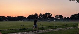 Sonnenuntergang auf einem Sportplatz.