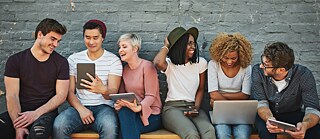 a group of people learn German on their mobile devices.