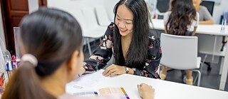 Zwei Schülerinnen mit Lehrerin im Klassenzimmer