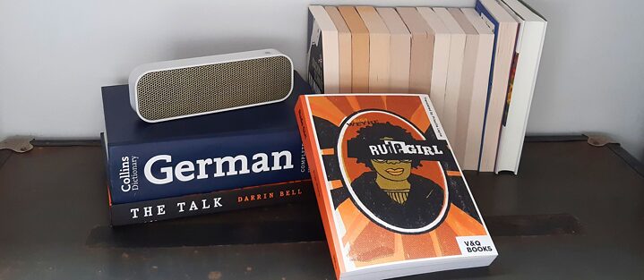The books 'Rude Girl' and 'The Talk' amongst a German dictionary and other books lying on a loud speaker