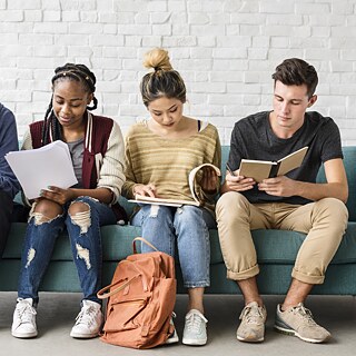 Several young school students sit next to each other on a sofa and read. The pictures in the ‘YOUNG LEARNERS’ series show groups of young learners - children and teenagers - who are having fun with education, learning and the German language.