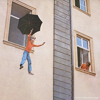 Ein Junge springt mit einem Regenschirm aus dem Fenster. Eine Szene aus dem Film "Das fliegende Klassenzimmer" aus dem Jahr 1973 nach dem gleichnamigen Roman von Erich Kästner.