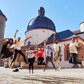  TOP Fellows jumping in front of historic building