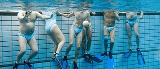 People in a swimming pool playing underwater rugby