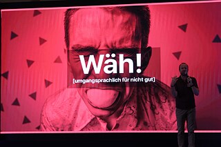 Prof. Dr. Thomas Strasser on stage in front of red screen