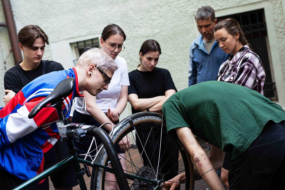 People standing close and having a look at the bicycle