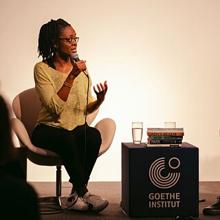 Sharon Dodua Otoo sits on the stage of the Goethe-Institut Sydney and is interviewed.