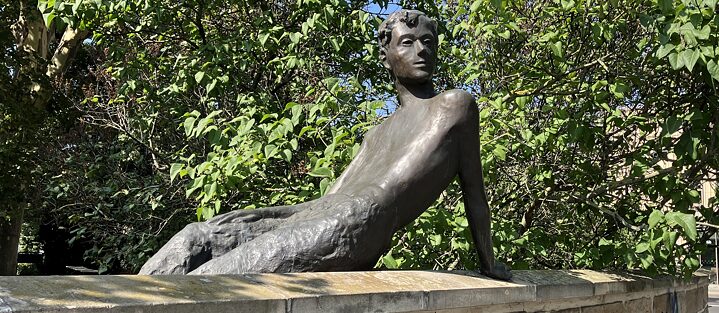 Eine Bronzestatue von Erich Kästner als Junge, der aus der Villa Augustin am Albertplatz in Dresden blickt. 