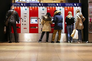 Menschen vor Fahrkartenautomat im Kölner Hauptbahnhof