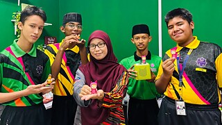 SMK Agama Putrajaya male students and teacher holding the Kreative Tonie figurines and the green Toniebox