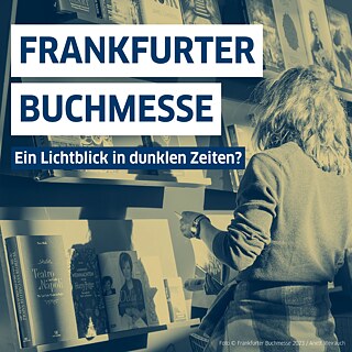 Auf dem Bild steht eine Person vor einem Bücherregal.