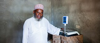 Shaame Kombo at the weighing scale in his fish-shop