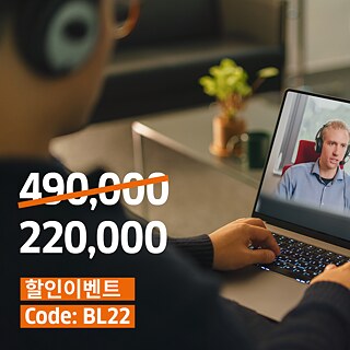 한 남성이 소파에 앉아 헤드폰을 끼고 노트북으로 작업하고 있습니다.