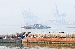 Fähre mitten auf dem Ozean an einem nebligen Morgen. Im Hintergrund ein Hafen.