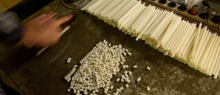 Several hundred handmade candles lie on a table.