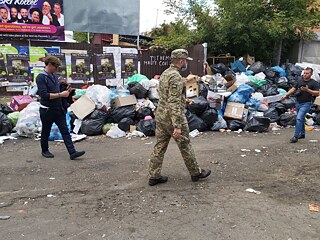 Ein ukrainischer Militärangehöriger geht an einem Müllhaufen vorbei, der sich im jüdischen Viertel angesammelt hat.