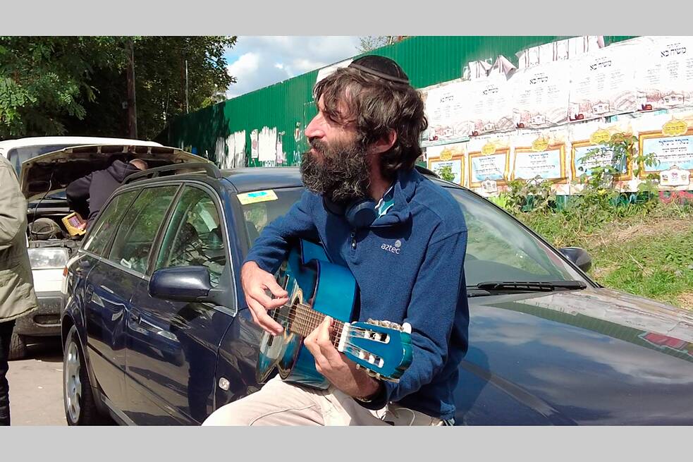 Der Pilger Michael spielt auf seiner Gitarre ein chassidisches Lied. Musik ist ein wichtiger Bestandteil chassidischer Rituale.