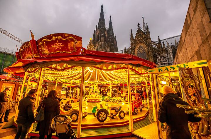 Festlich beleuchtetes Kinderkarussell  auf dem Weihnachtsmarkt vor dem Kölner Dom