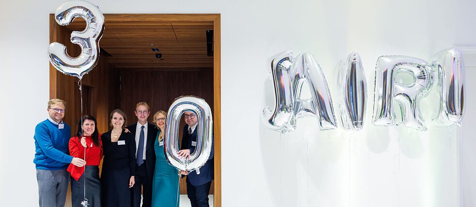  Participants of the anniversary event pose with silver balloons with the words 30 years written on them.