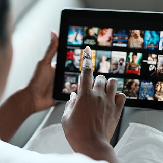 A lady perusing movie options on her tablet