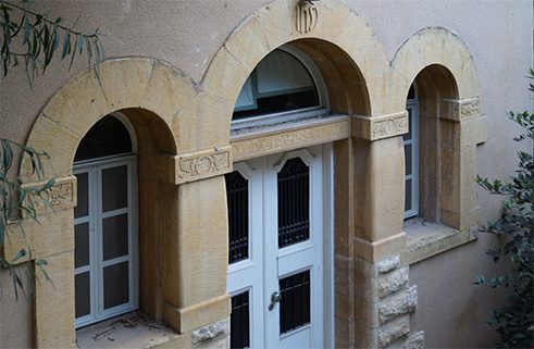 Keystone above the entrance to the former German parish house on campus of École Supérieure des Affaires