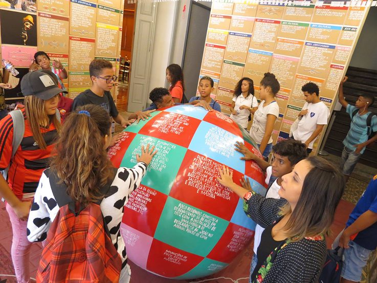 Crianças que participam do futebol social promovido pela Street Football World visitam exposição no Centro