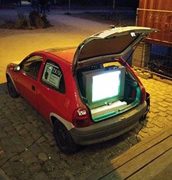 A TV set up in the boot of a car.